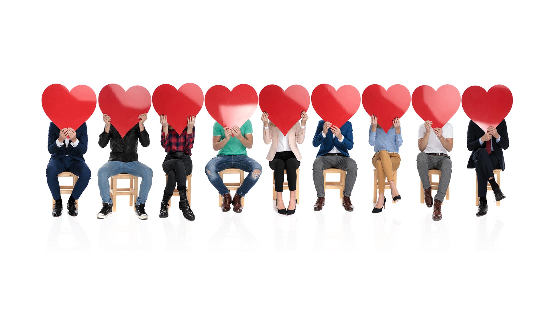 large group of people holding big red hearts over their faces, c