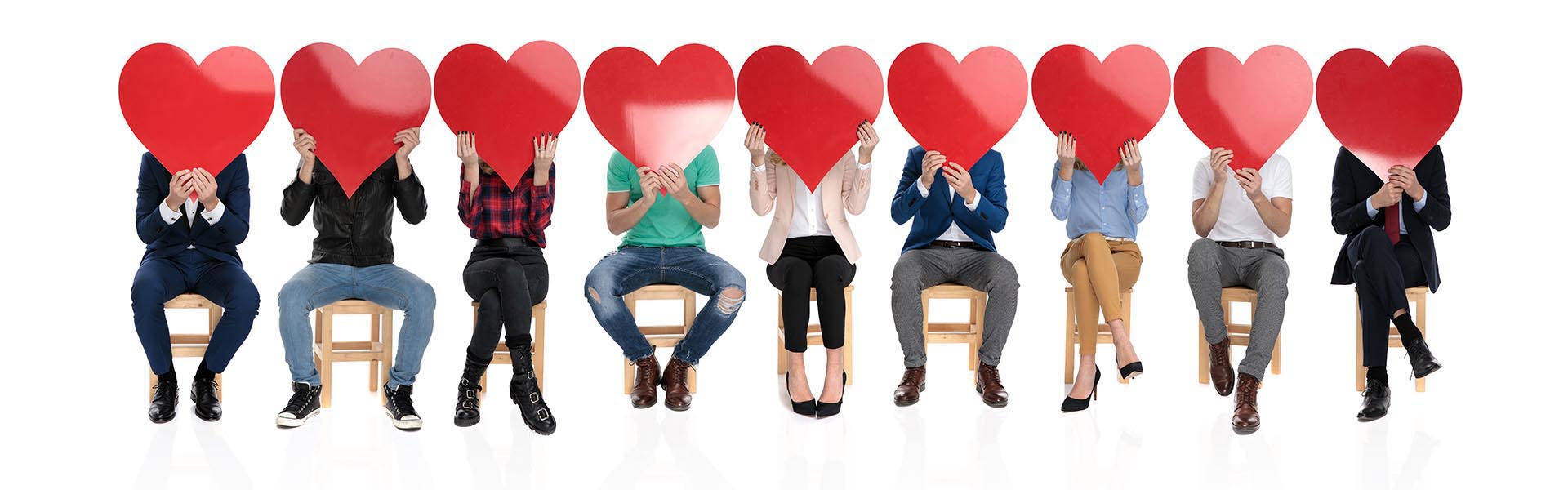 large group of people holding big red hearts over their faces, c